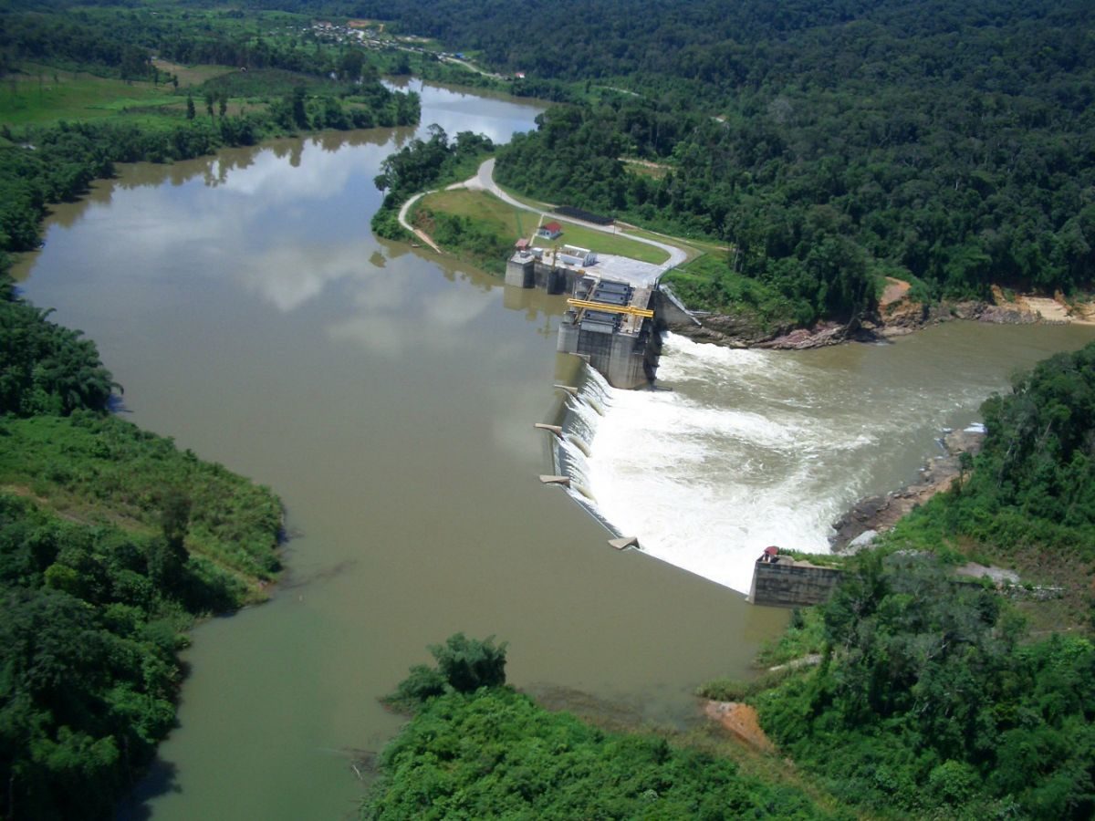 Aerial view of a hydropower dam and headpond in forested terrain.