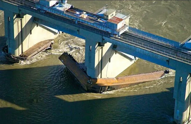 Barges twisted around piers afer being swept away from Belleville Locks.